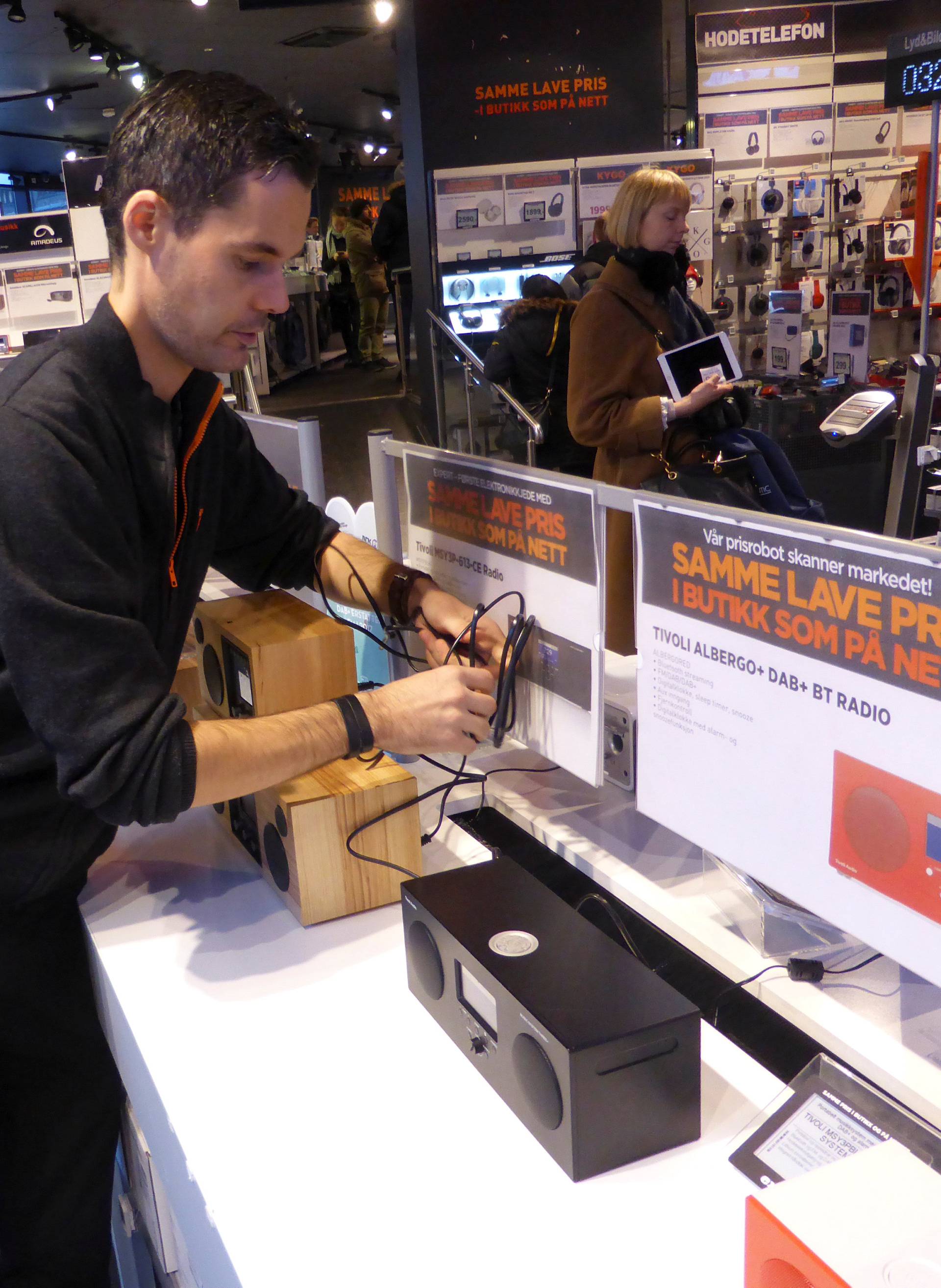 Worker Nilsen arranges digital radios in an Expert City electronics shop in Oslo