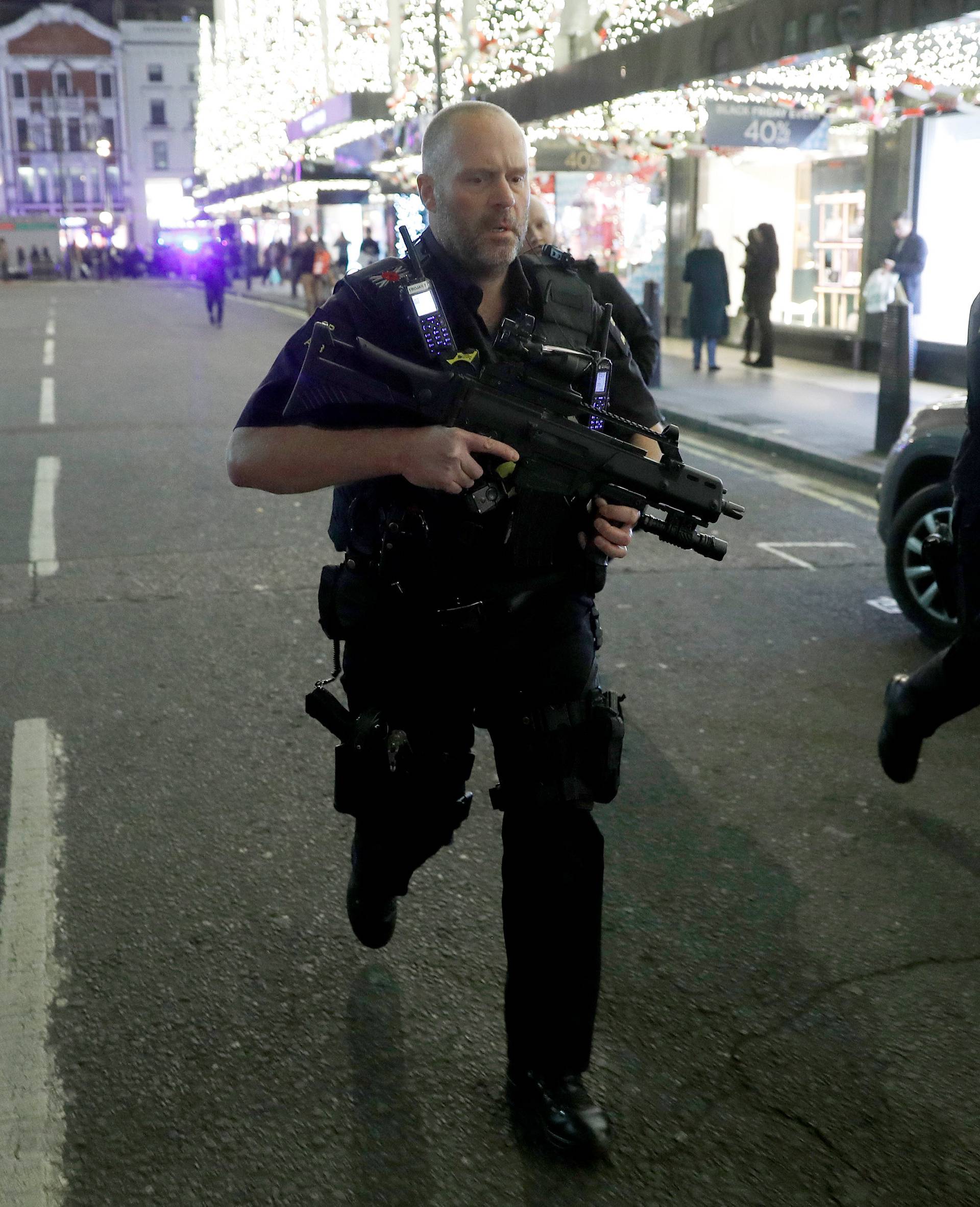 Armed police run along Oxford Street, London