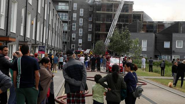 Firefighters work on top of a block of flats after a fire broke out in Barking