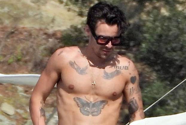 *PREMIUM-EXCLUSIVE* MUST CALL FOR PRICING BEFORE USAGE  - Harry Styles shows off his toned physique and his impressive array of tattoos on his Italian holiday with friends James Corden and Victoria's Secrets lingerie model Jacquelyn Jablonski out on Lake