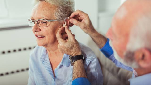 Older woman and man or pensioners with a hearing problem