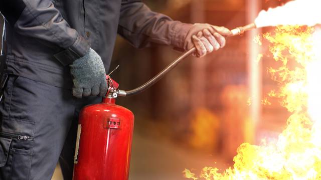 Man,Using,Fire,Extinguisher,Fighting,Fire,Closeup,Photo.