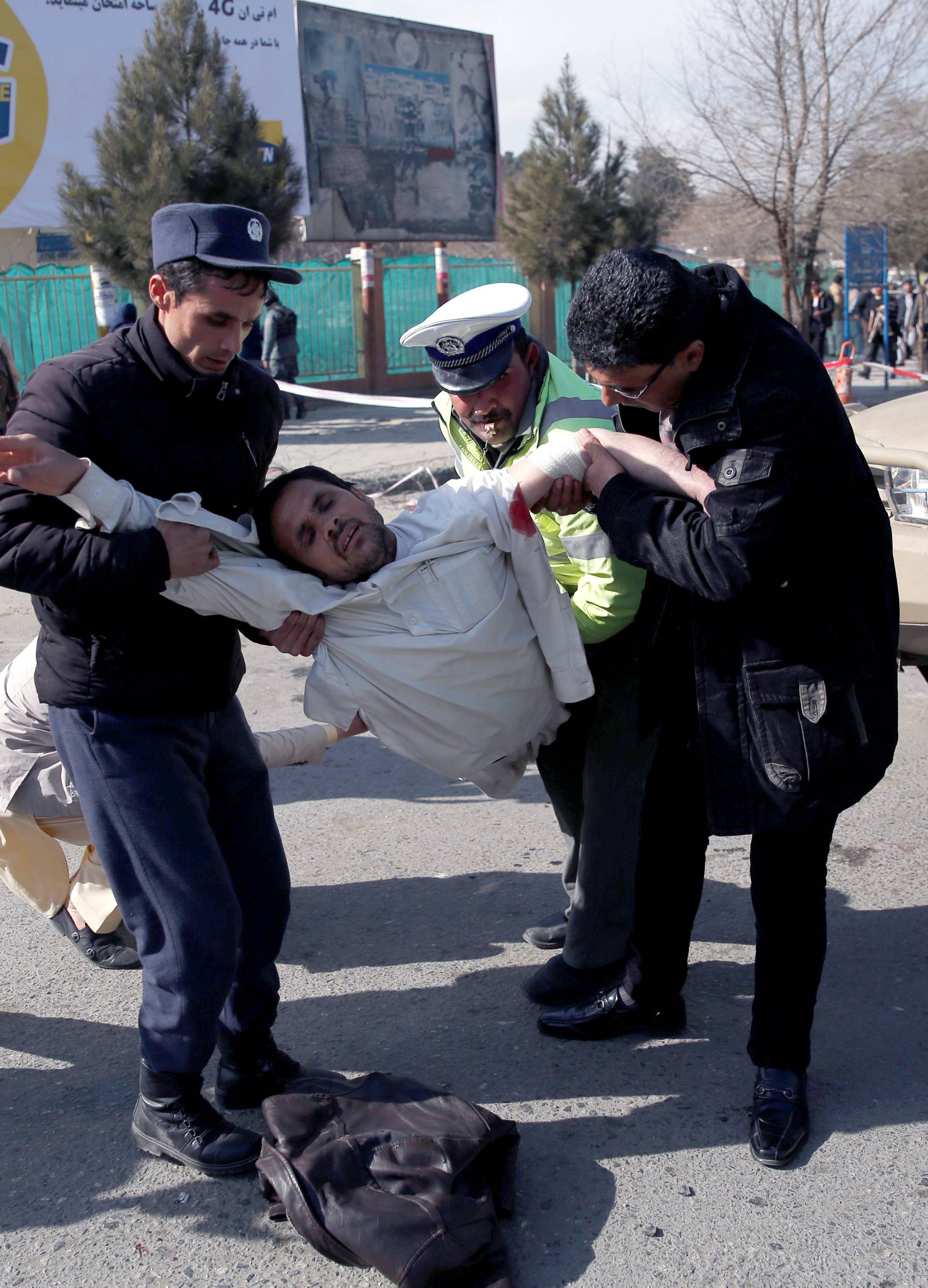 People carry an injured man after a blast in Kabul
