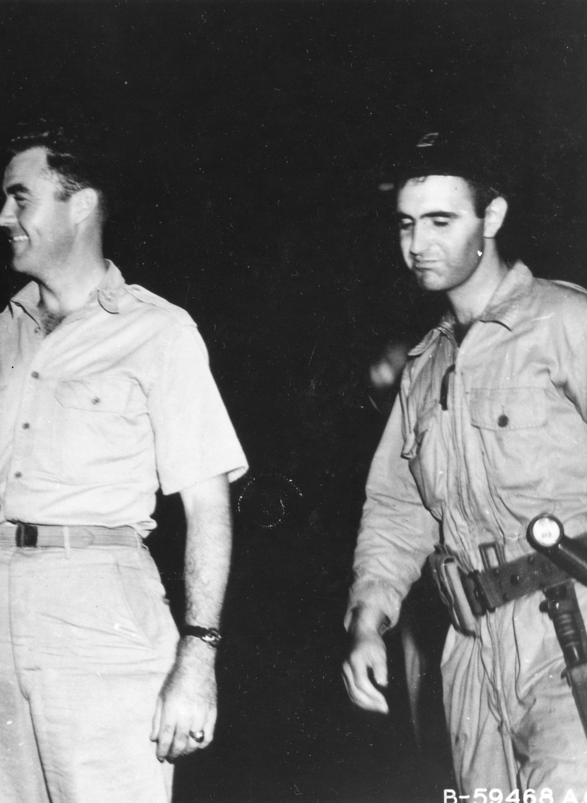 Major Charles W. Sweeney (left), pilot of the B-29 BOCKSCAR which dropped the atomic bomb on Nagasaki on August 9, 1945, is shown before his mission shaking hands with Col Paul W. Tibbets, pilot of ENOLA GAY which atom bombed Hiroshima on 6 August 1945. M