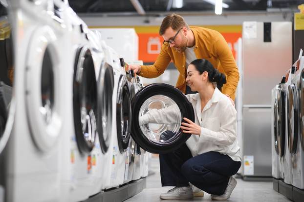 Young,Couple,Choosing,Washing,Machine,In,Hypermarket
