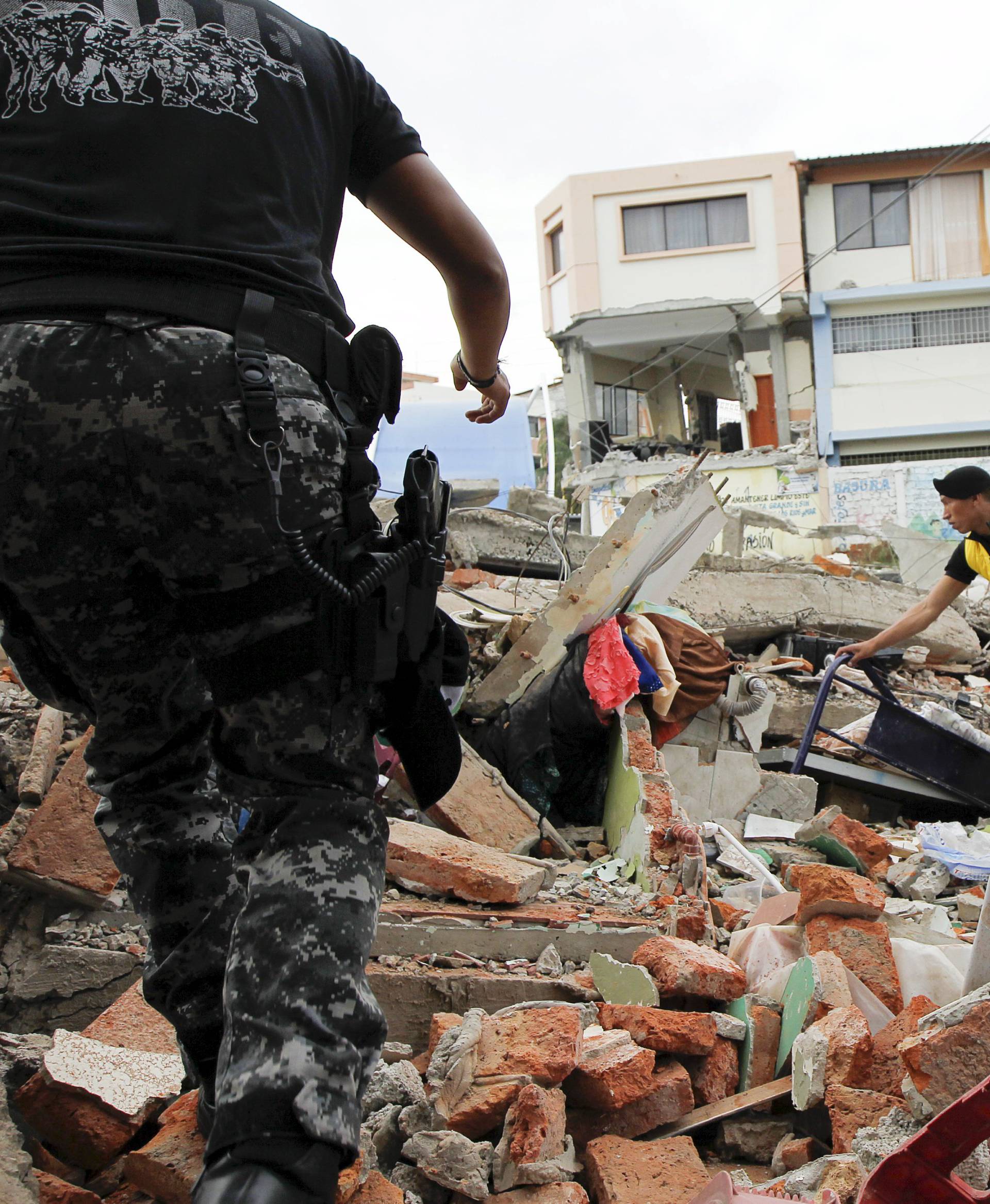 Red Cross members, military and police officers work at a collapsed area after an earthquake struck off Ecuador's Pacific coast, at Tarqui neighborhood in Manta