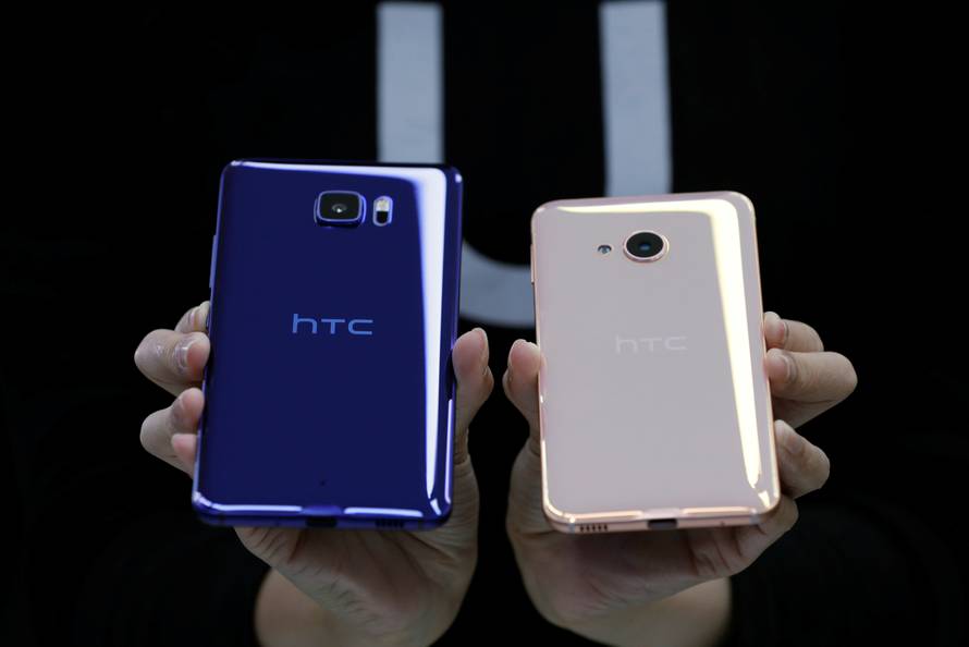 A member of staff poses with a new HTC smartphone "U Ultra" and "U Play" after their launch event in Taipei