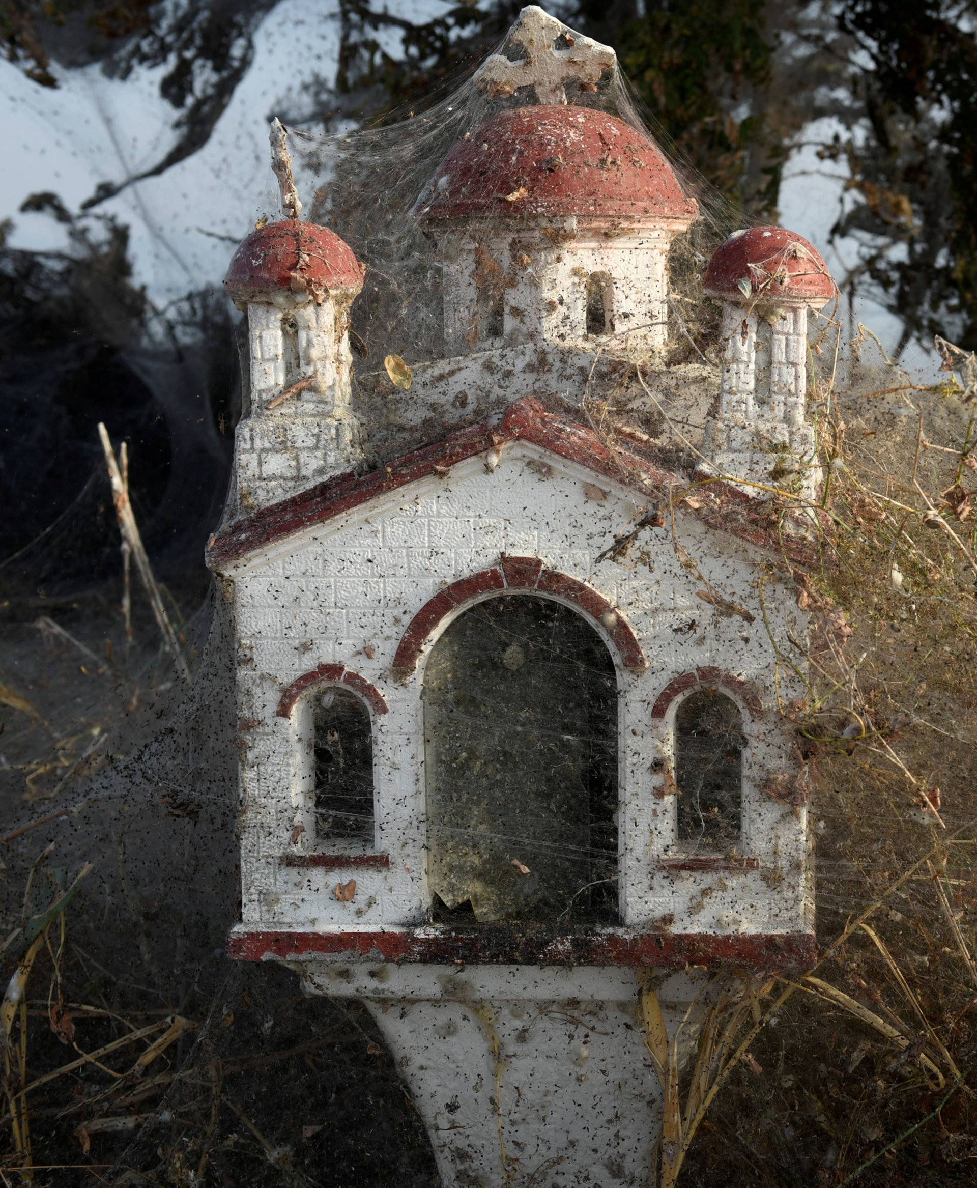 Spider webs cover a roadside shrine at the banks of Lake Vistonida