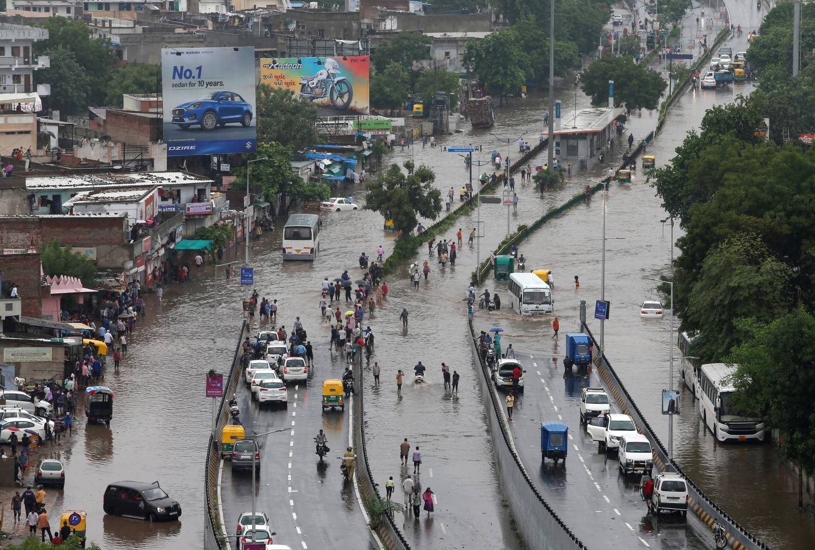 People commute through water-logged roads after heavy rains in Ahmedabad