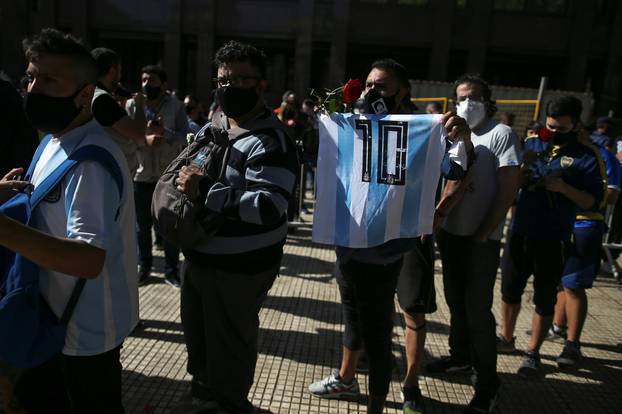 People wait in line outside the Casa Rosada presidential palace ahead of the wake of late soccer legend Diego Maradona, in Buenos Aires