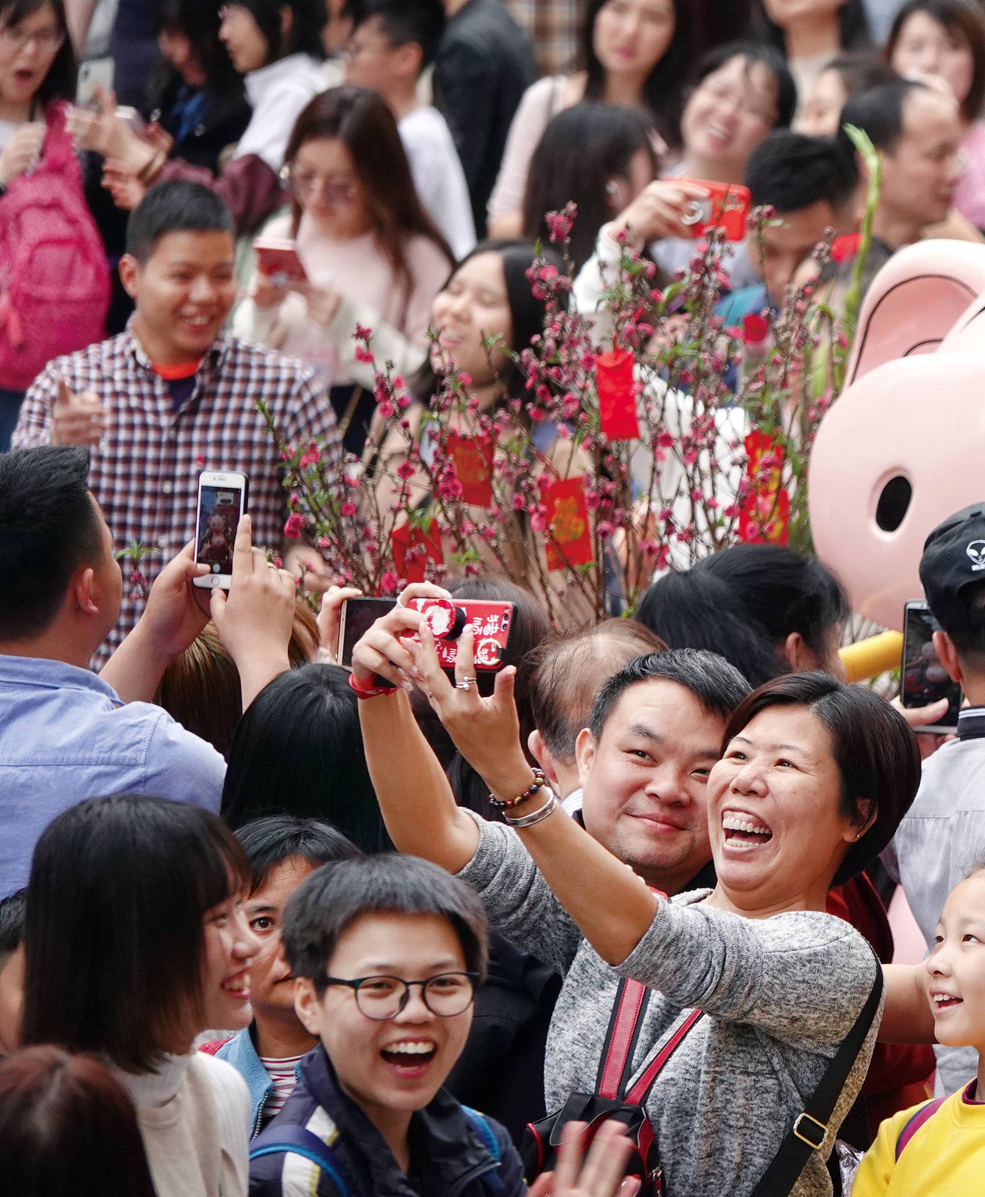 Visitors take pictures of an installation at a flower fair ahead of the Chinese Lunar New Year of the Pig, in Guangzhou