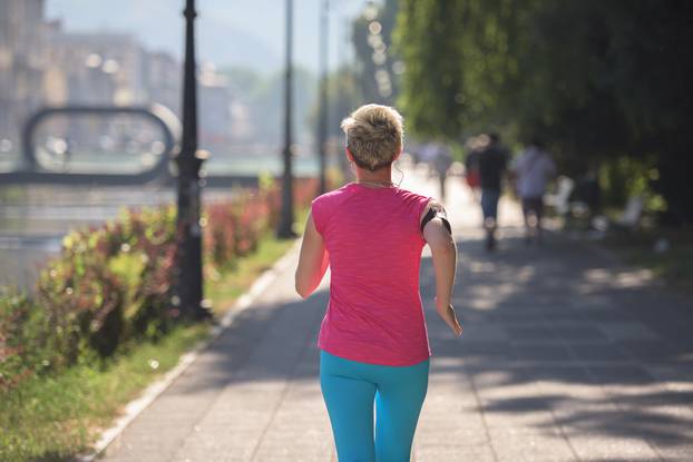 sporty woman running  on sidewalk