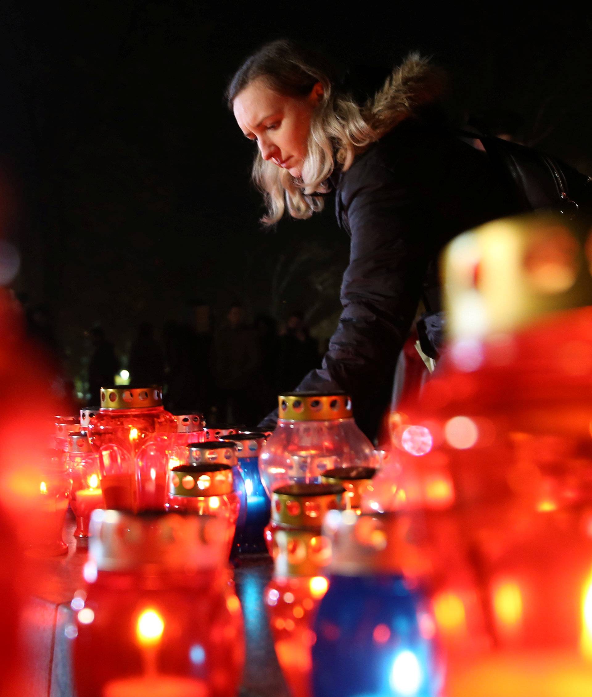 A Bosnian Croat woman lights a candle for the convicted general Slobodan Praljak, who killed himself seconds after the verdict in the U.N. war crimes tribunal in The Hague, in Mostar