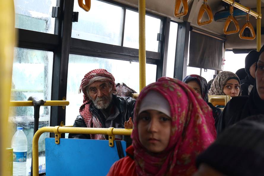 Evacuees from the Shi'ite Muslim villages of al-Foua and Kefraya ride a bus at insurgent-held al-Rashideen in the province of Aleppo