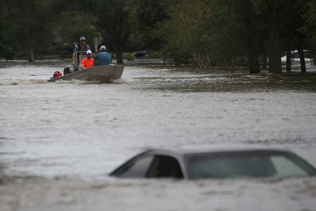 A rescue boat evacuates people from the rising waters of Buffalo Bayou following Hurricane Harvey in a neighborhood west of Houston