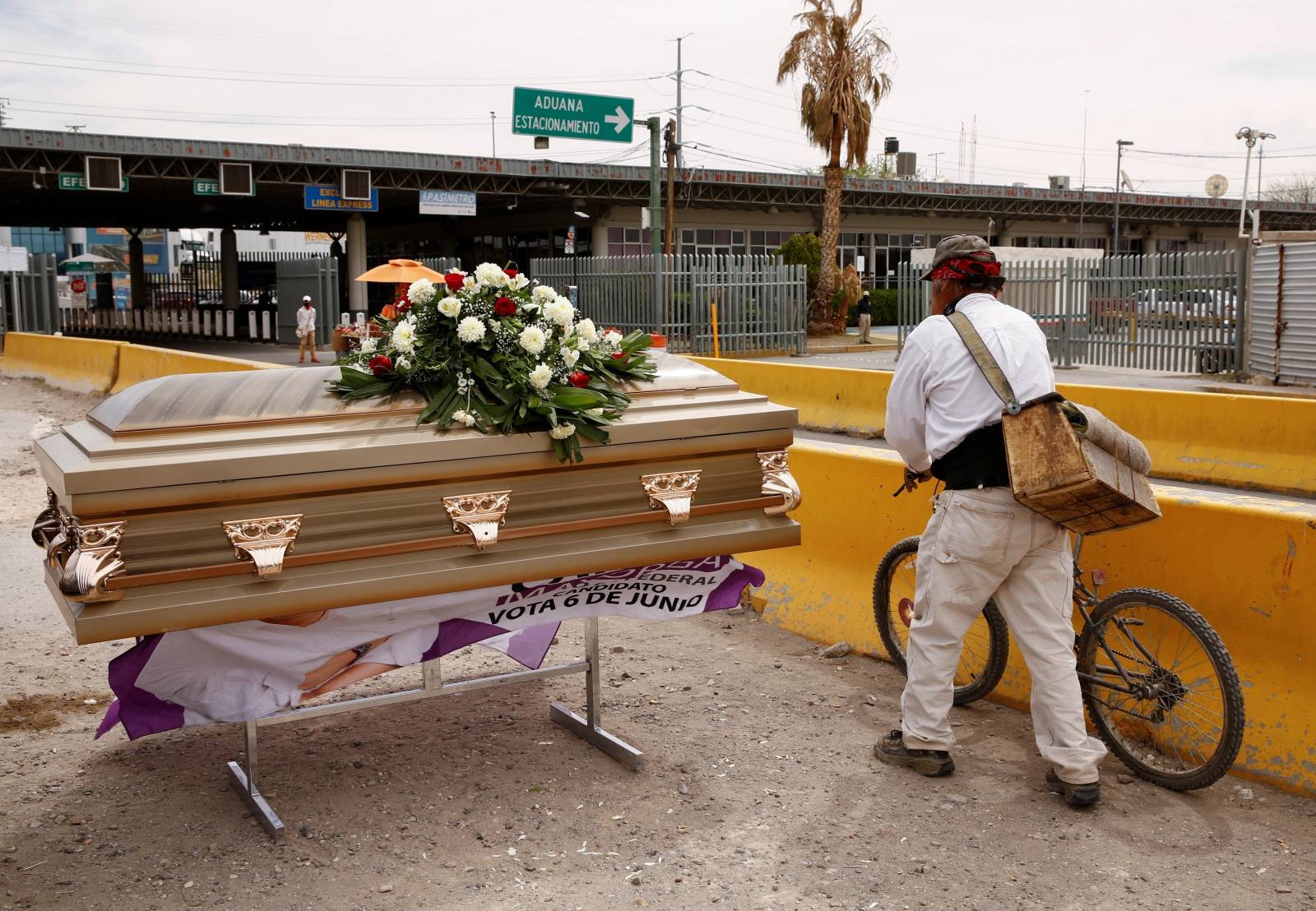 A man passes by a coffin that was used by Carlos Mayorga, a Mexican candidate for federal representative as part of his campaign slogan "If I don't deliver, let them bury me alive" near the Zaragoza-Ysleta international border bridge in Ciudad Juarez