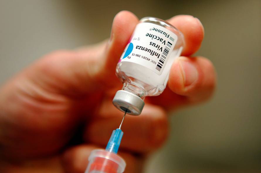 FILE PHOTO: A nurse prepares an injection of the influenza vaccine at Massachusetts General Hospital in Boston, Massachusetts