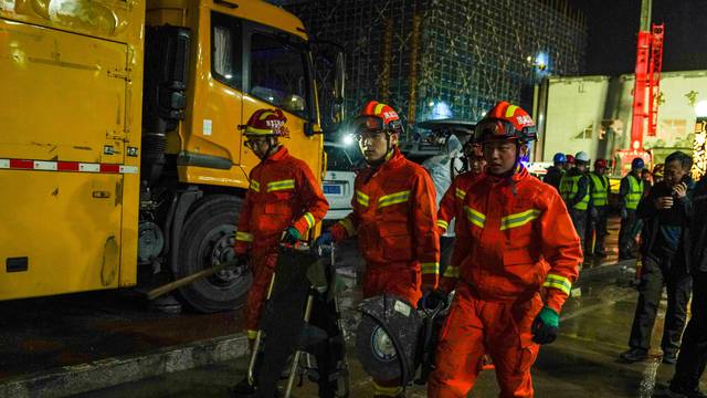 Firefighters at the site where the roof of a school gymnasium collapsed, in Qiqihar