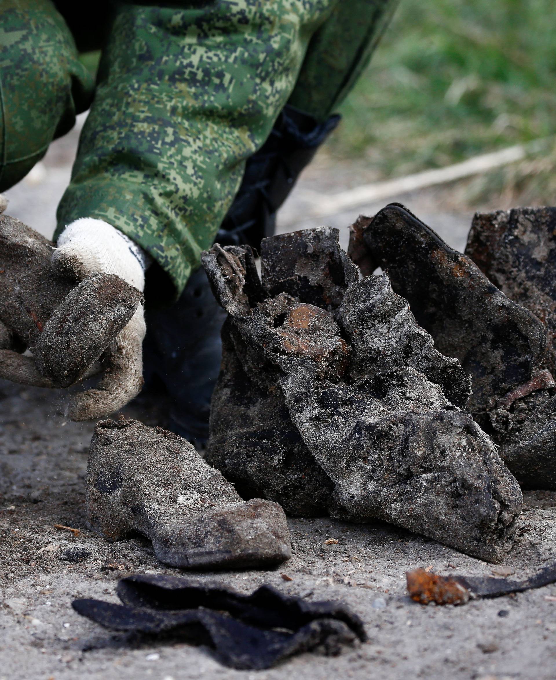 A soldier from a special "search battalion" of Belarus Defence Ministry takes part in the exhumation of a mass grave containing the remains of about 730 prisoners of a former Jewish ghetto, discovered at a construction site in the centre of Brest