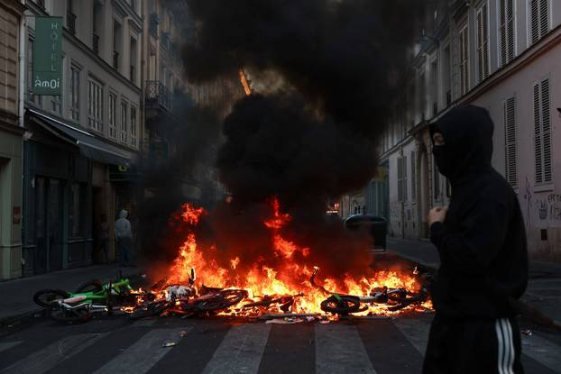 Police officers in riot gear stand guard, the day after a national day of demonstrations against the cost of living and rising fuel prices, in Paris