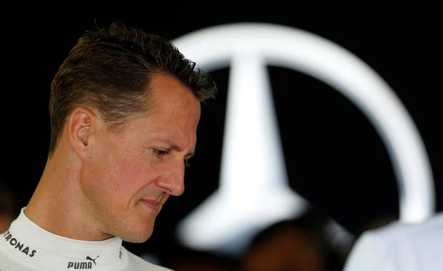 FILE PHOTO: Mercedes Formula One driver Schumacher stands inside his team garage during the first practice session of the Japanese F1 Grand Prix at the Suzuka circuit