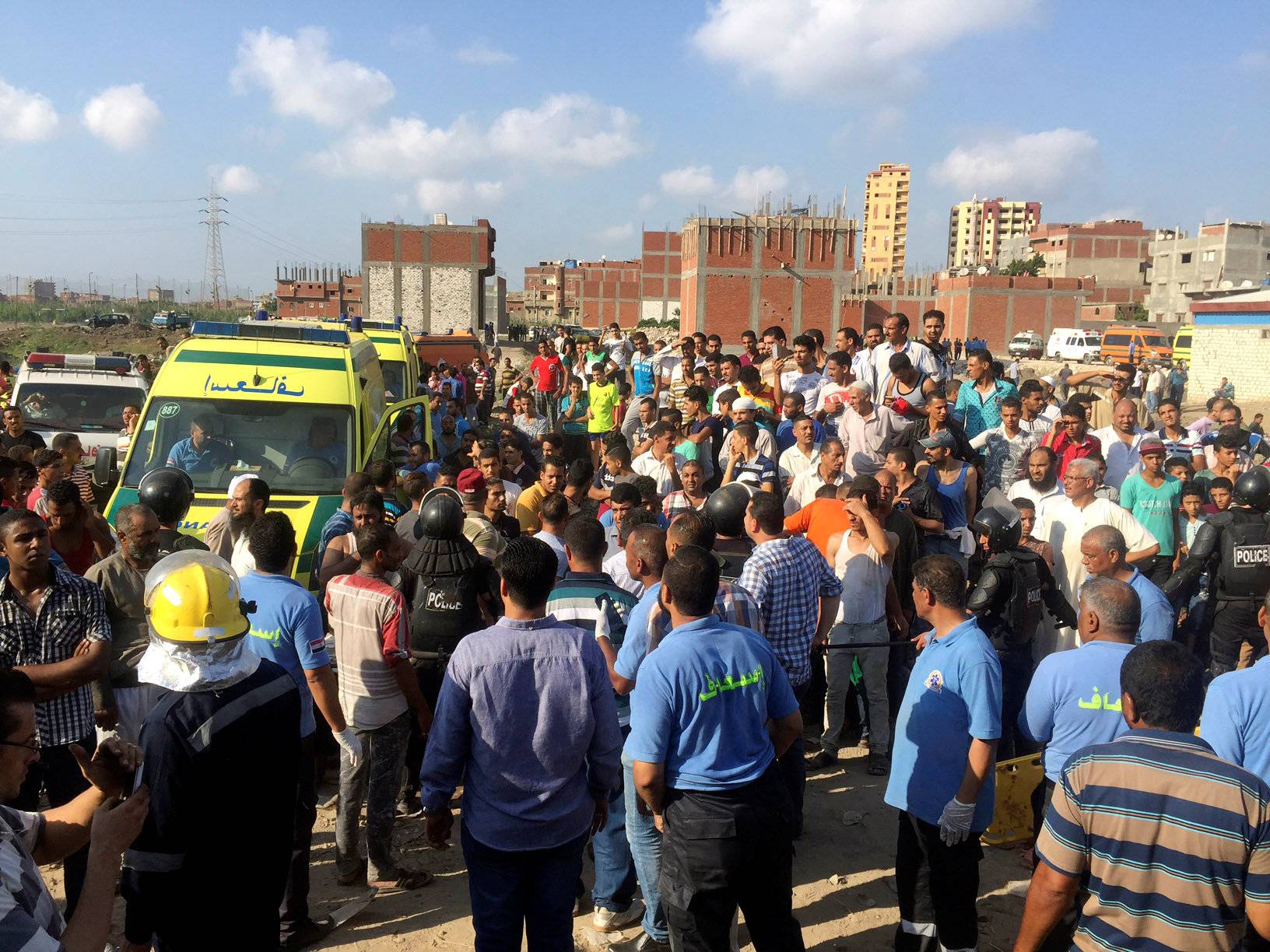 Egyptians and security personnel are seen at the site of a crash where two trains collided near the Khorshid station in Egypt's coastal city of Alexandria