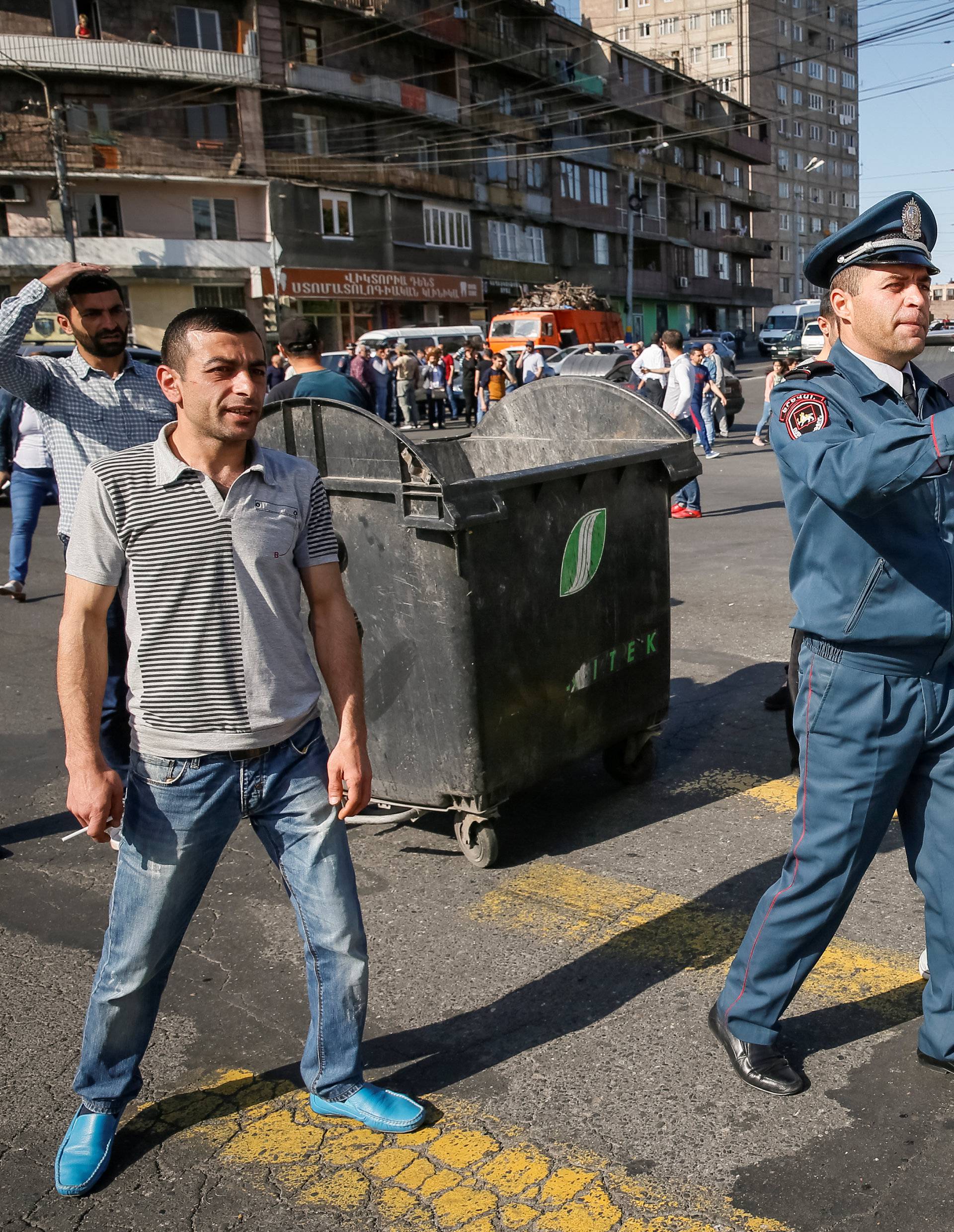 A policeman gestures as Armenian opposition supporters block a road, after protest movement leader Nikol Pashinyan announced a nationwide campaign of civil disobedience in Yerevan