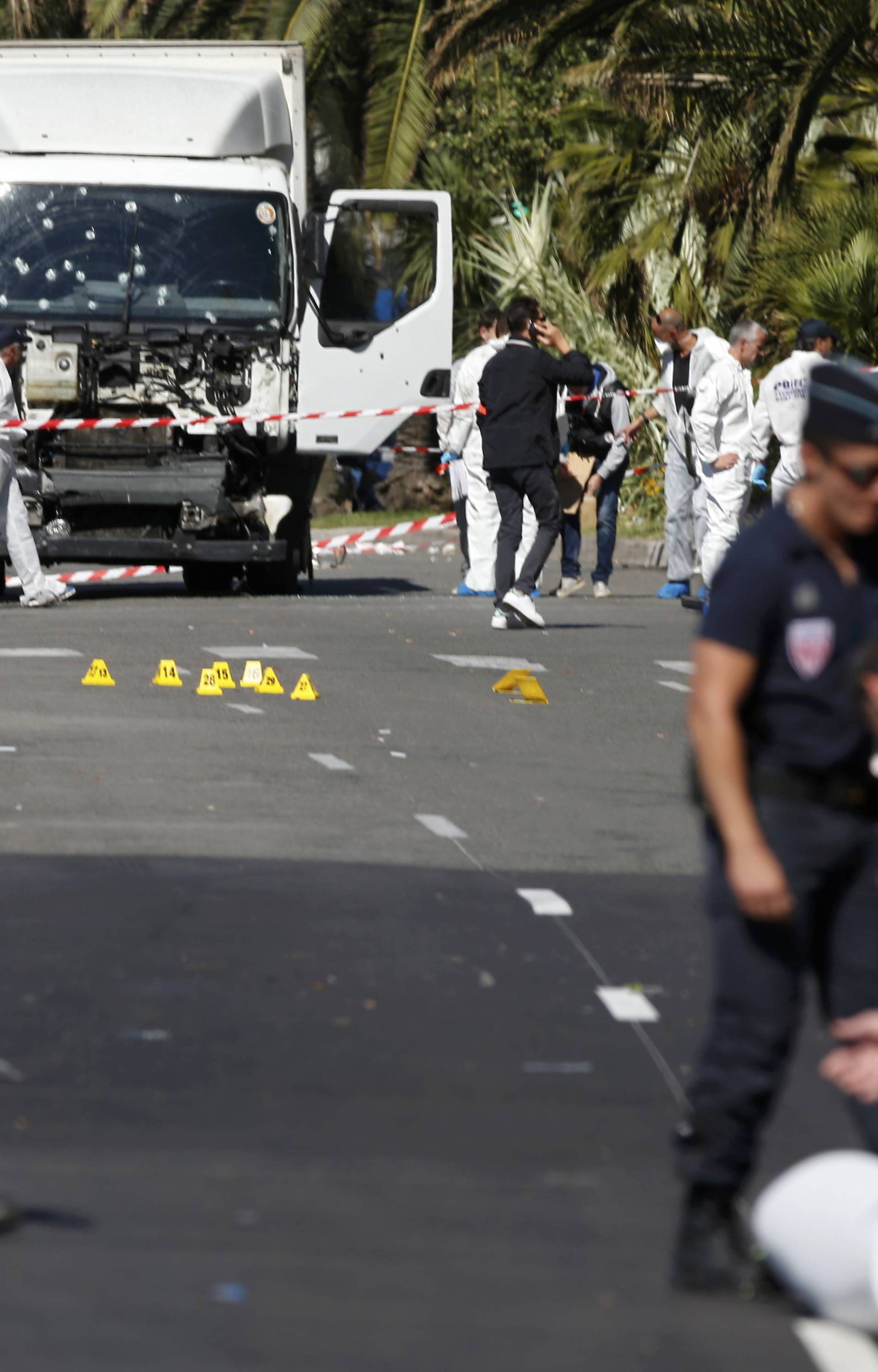 French police secure the area as the investigation continues at the scene near the heavy truck that ran into a crowd at high speed killing scores who were celebrating the Bastille Day July 14 national holiday on the Promenade des Anglais in Nice
