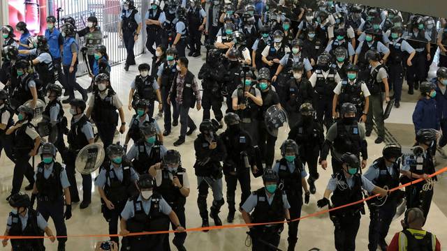 Police officers wearing face masks to avoid the spread of the coronavirus disease (COVID-19) disperse anti-government protesters from a shopping mall during a rally in Hong Kong