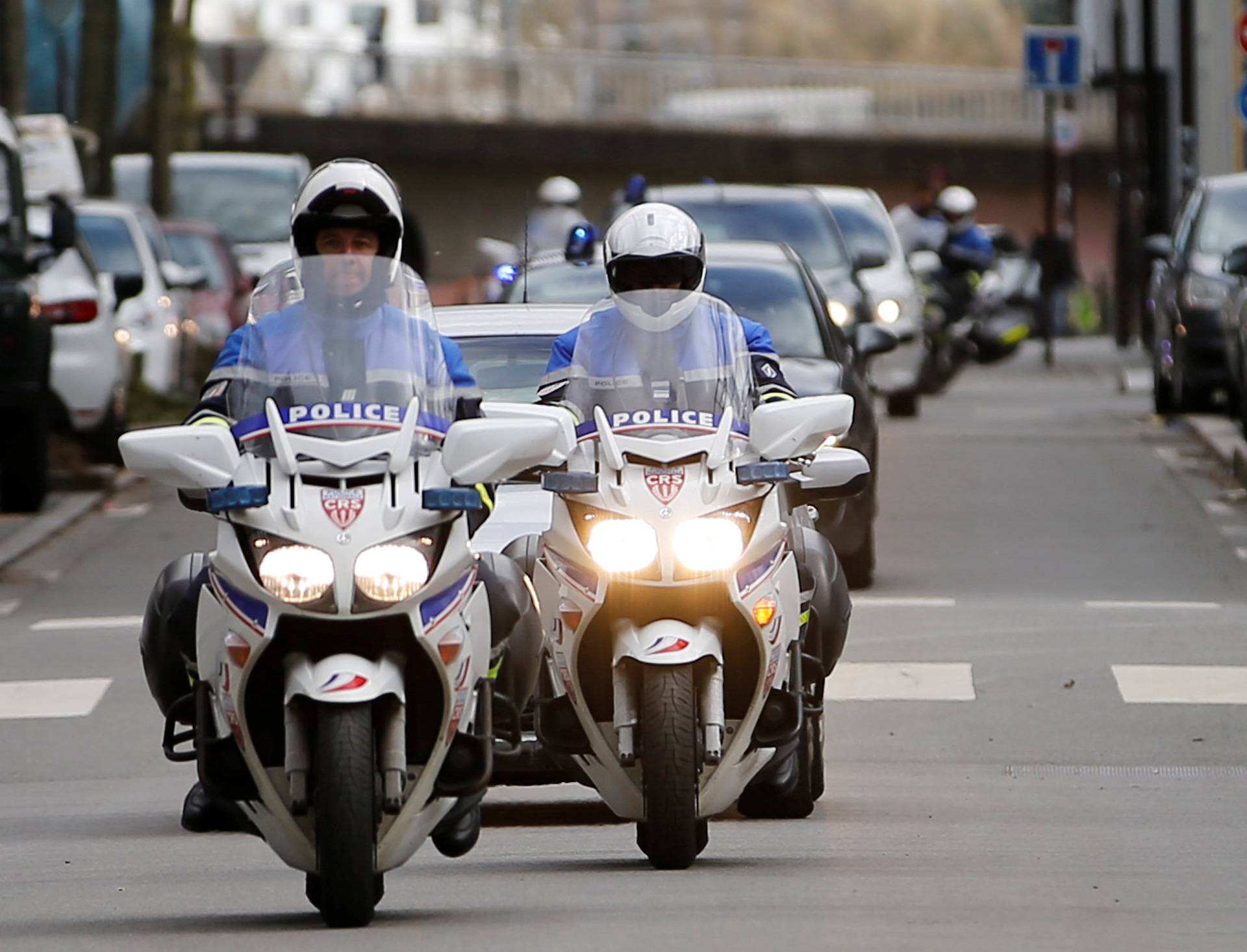 French police escort vehicules believed to transport the sister and brother-in-law of Pascal Troadec as they arrive at the courthouse in Nantes