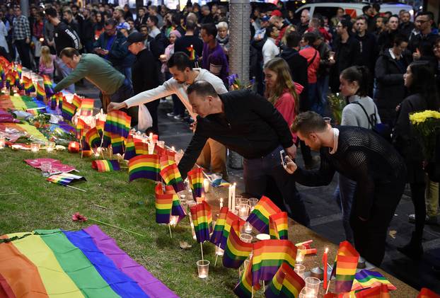 People gather at a vigil in solidarity for the victims of the Orlando nightclub mass shooting, at Taylor Square in Sydney