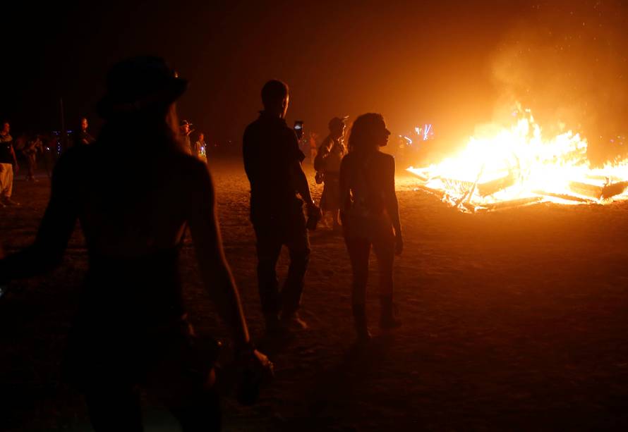 Participants approach a burning art installation as approximately 70,000 people from all over the world gathered for the annual Burning Man arts and music festival in the Black Rock Desert of Nevada