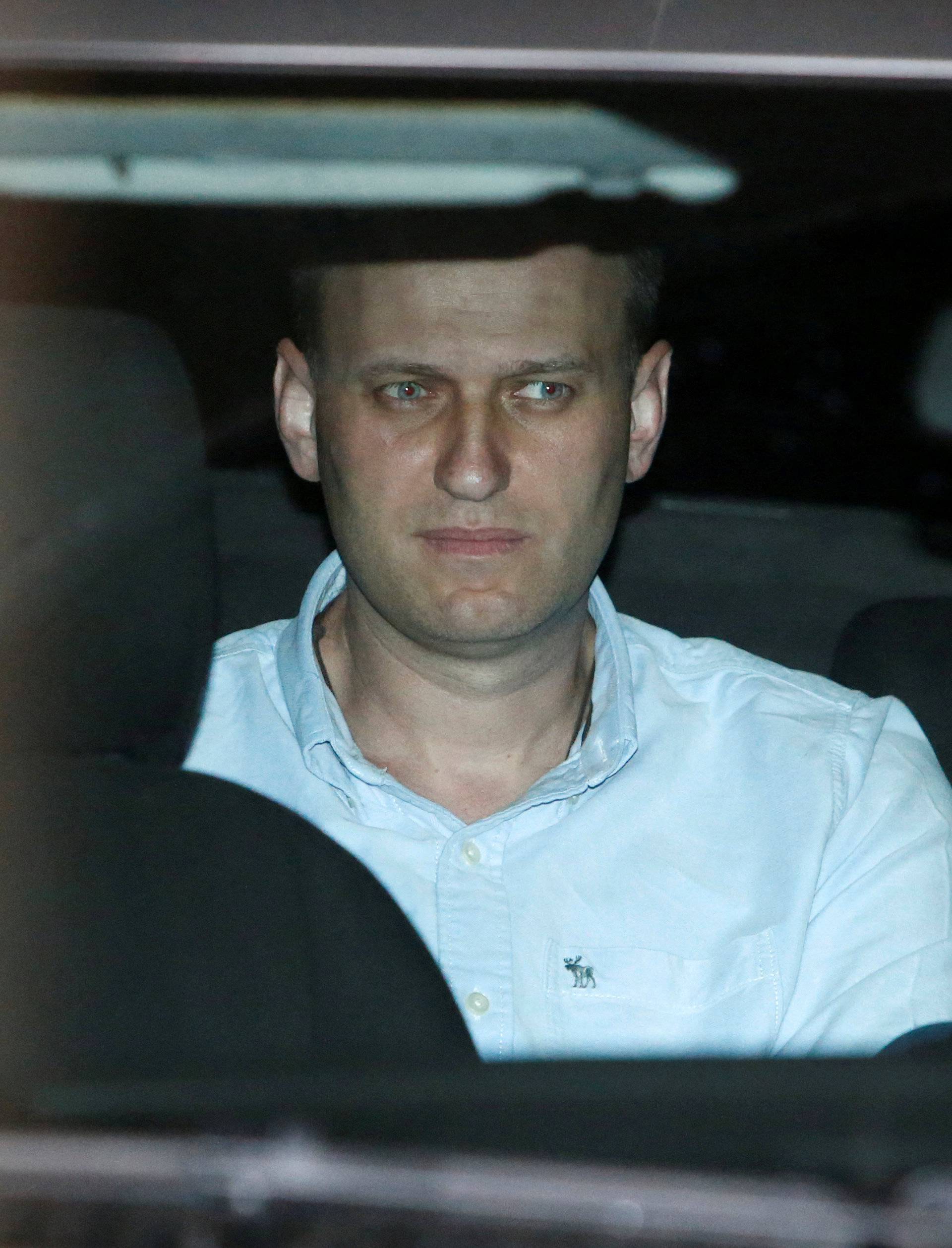 Russian opposition leader Navalny sits in a police car after being found guilty by a court of repeatedly violating the law on organizing public meetings, in Moscow
