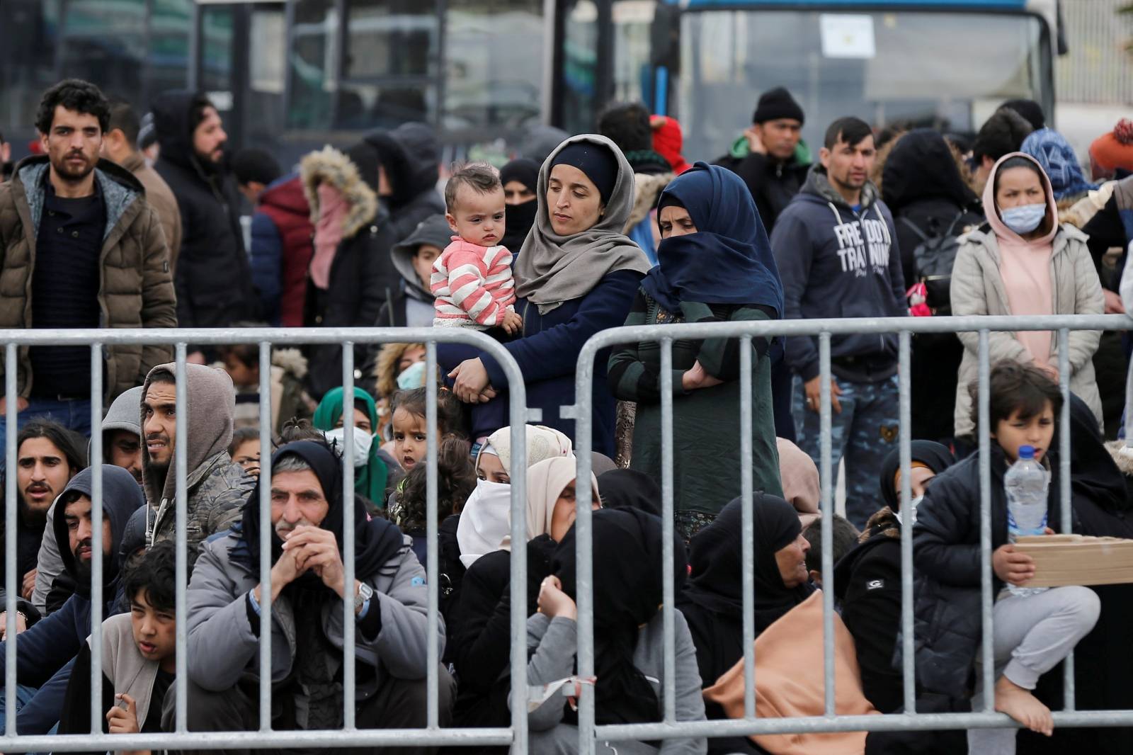 Migrants who arrived on the island of Lesbos in the past four days, are seen at the port of Mytilene, as they wait to board a Greek navy ship, in Mytilene