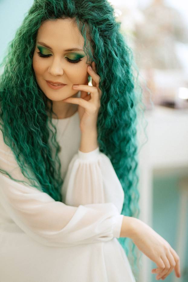 portrait of a bride with green curly hair in the beauty room