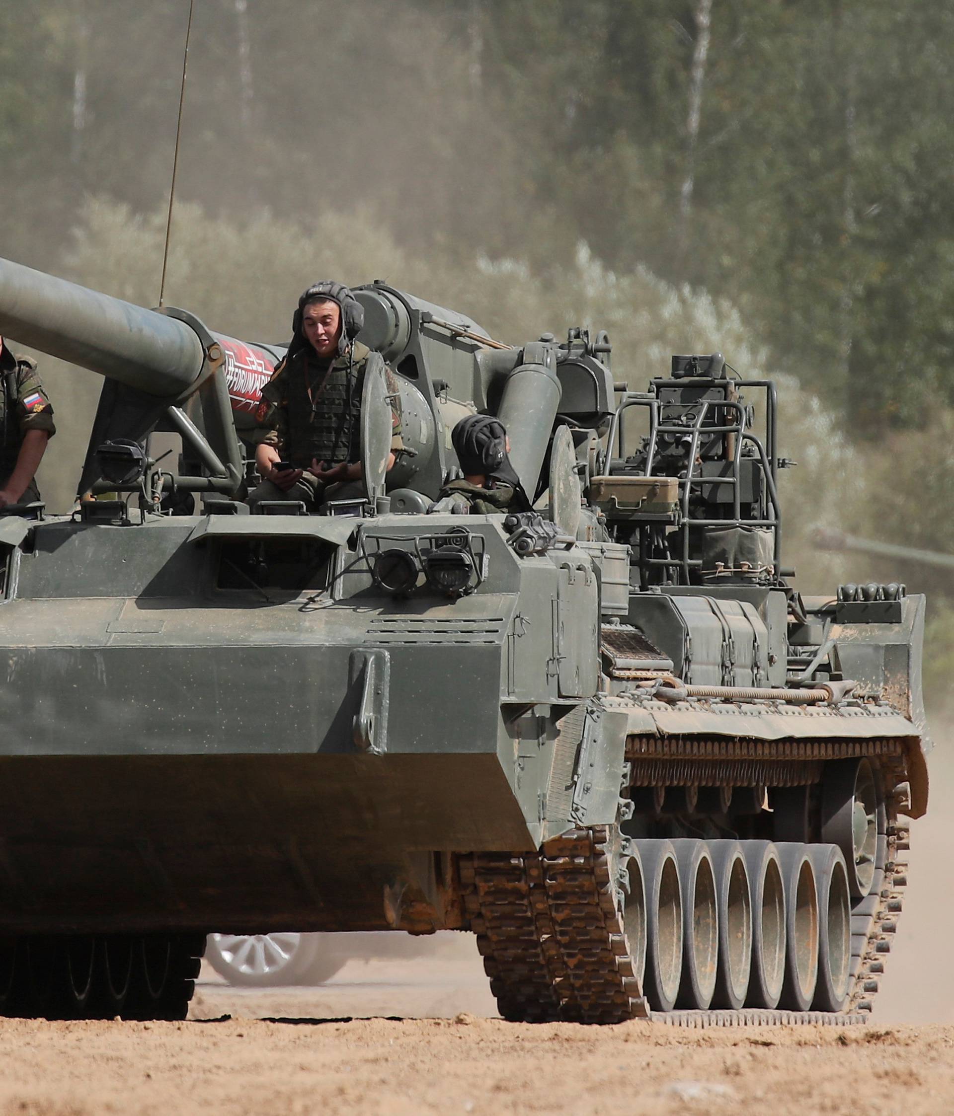 Russian servicemen sit atop a 2S5 Giatsint-S self-propelled howitzer during the annual international military-technical forum "ARMY" in Alabino