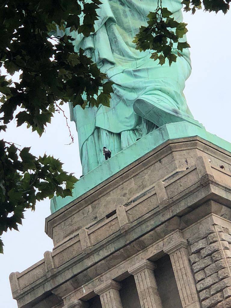 A protester is seen on the Statue of Liberty in New York
