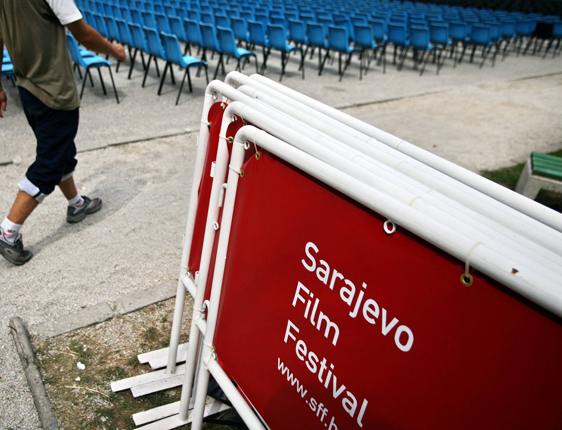 Organiser walks past seats at the open air cinema for the 12th Sarajevo Film Festival in Sarajevo