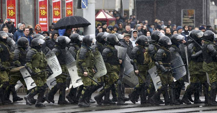 Law enforcement officers walk during a gathering which marks the anniversary of the proclamation of the Belarussian People's Republic in Minsk