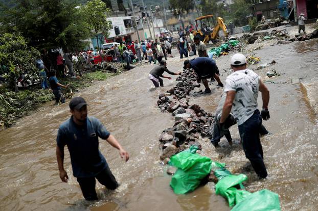 People clean up debris of the damage caused by heavy rainfall in the municipality of Ecatepec