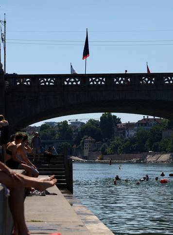 People swim in the Rhine river during a heatwave in Basel