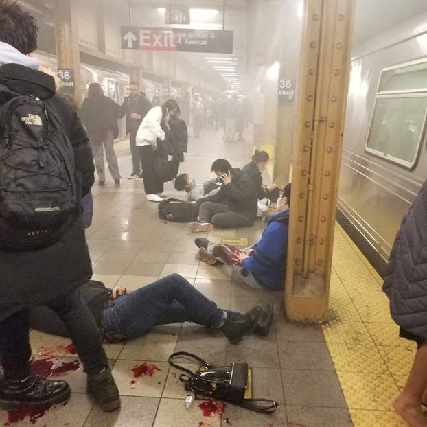 Wounded people lie at the 36th Street subway station, in New York City