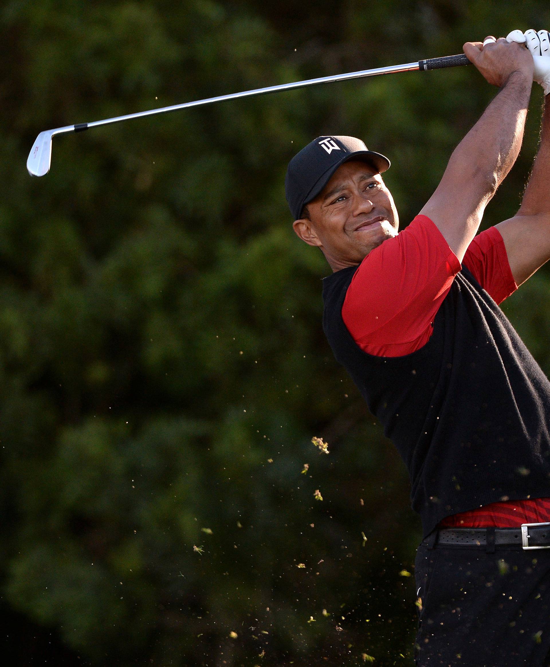 FILE PHOTO: Tiger Woods plays his shot from the 11th tee during the final round of the Farmers Insurance Open golf tournament at Torrey Pines Municipal Golf Course in San Diego