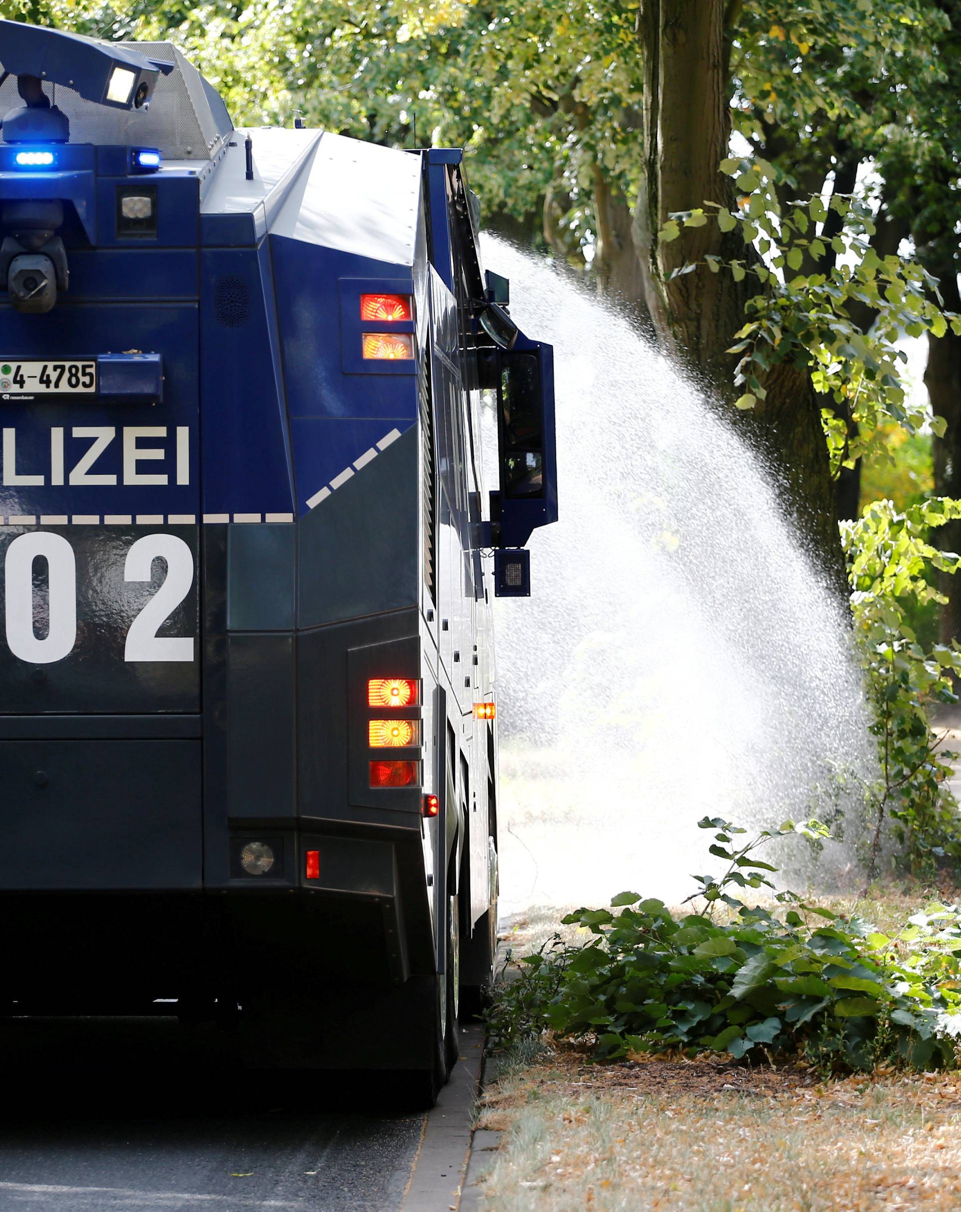 Police water cannon is used to hose water on alley trees in Bochum