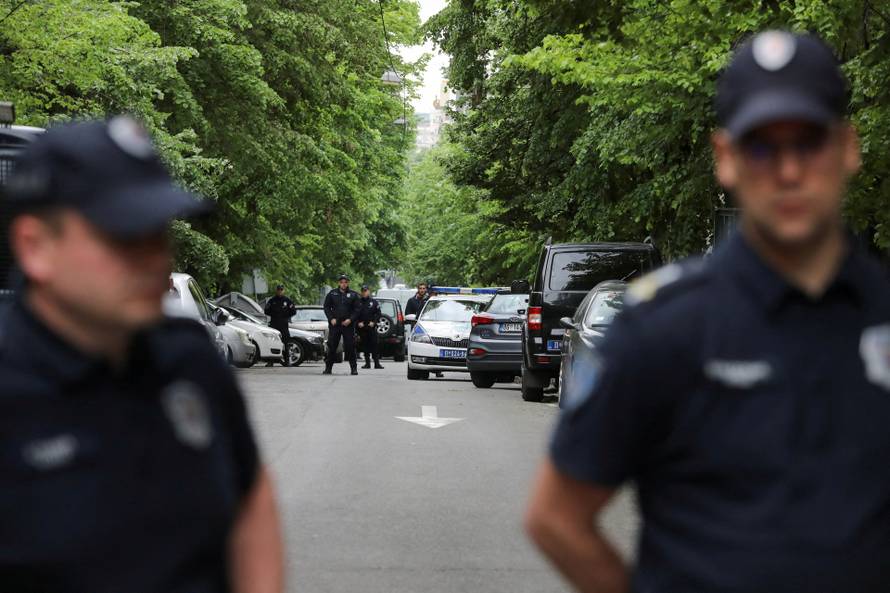 Police officers secure the area after a 14-year-old boy opened fire on other students and security guards at a school in downtown Belgrade