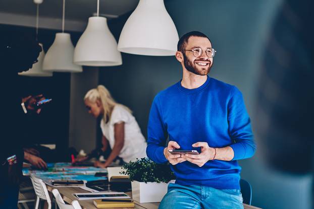 Smiling,Male,Employee,In,Casual,Clothes,And,Eyeglasses,Sitting,On