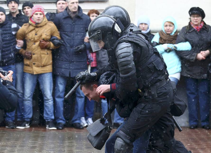 Law enforcement officers detain a man during a gathering which marks the anniversary of the proclamation of the Belarussian People's Republic in Minsk