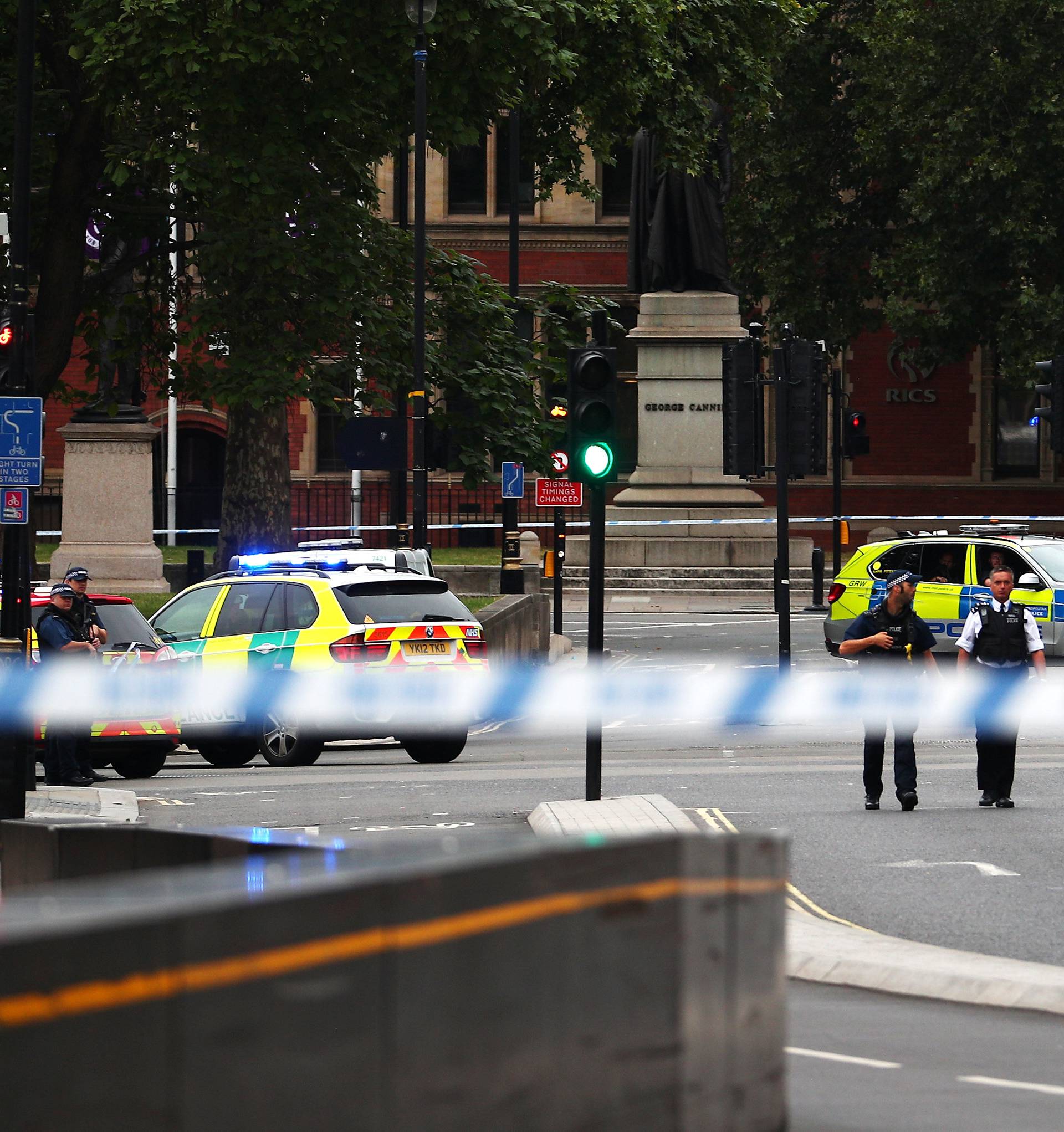 Armed police stand in the street after a car crashed outside the Houses of Parliament in Westminster, London