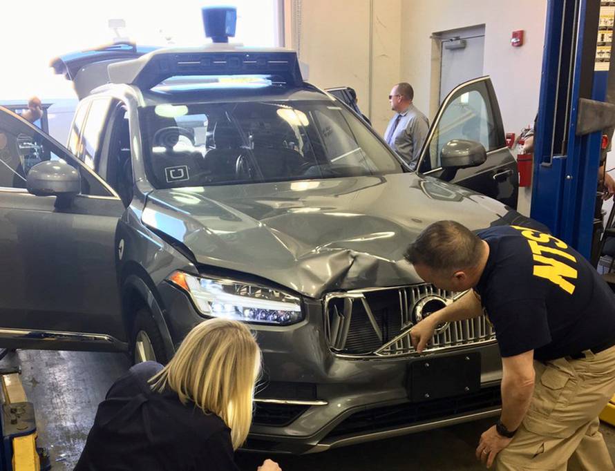 FILE PHOTO: NTSB investigators examine a self-driving Uber vehicle involved in a fatal accident in Tempe