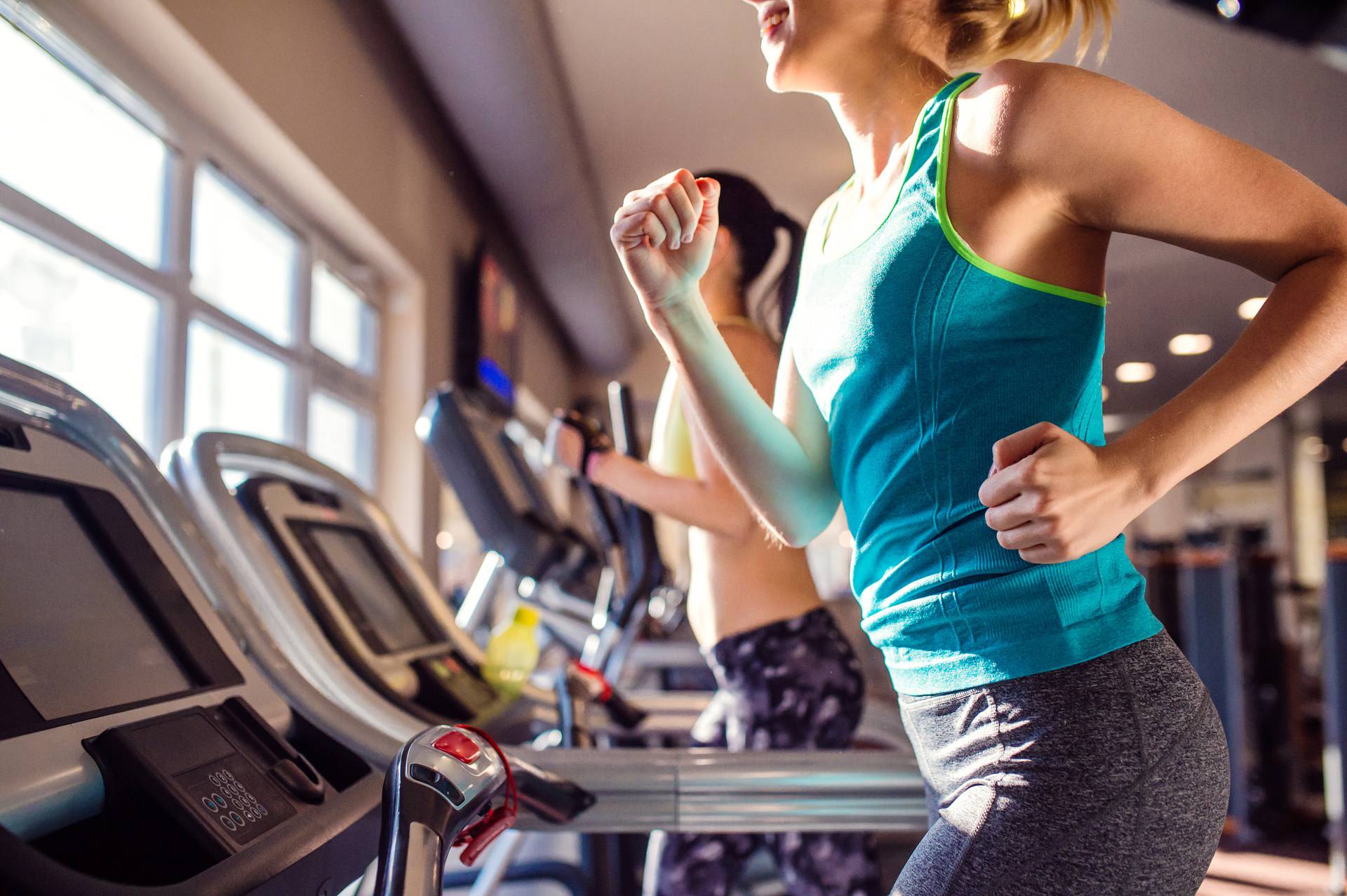 Two,Fit,Women,Running,On,Treadmills,In,Modern,Gym